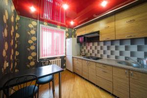 una cucina con armadi in legno, tavolo e lavandino di Apartment at Pervomayskaya a Mogilev