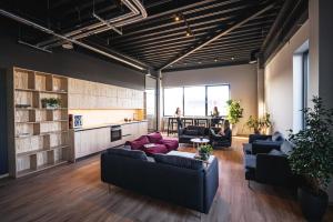 a living room with couches and a table at Light House Coliving in Klaipėda