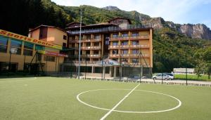 un campo da basket di fronte a un edificio di Olymp Hotel a Teteven