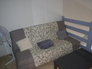 ein Sofa im Wohnzimmer mit einem Kissen darauf in der Unterkunft Duplex T2 mezzanine, Saint Pierre la Mer in Saint Pierre La Mer