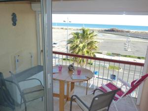 einen Balkon mit einem Tisch und Stühlen sowie Strandblick in der Unterkunft Duplex T2 mezzanine, Saint Pierre la Mer in Saint Pierre La Mer
