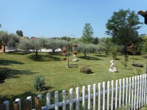 a garden with trees and a white fence at La Cigale in Malaucène