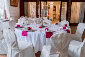 einen Tisch mit weißen Stühlen und einen weißen Tisch mit rosa Akzenten in der Unterkunft Hotel Everest in Węgrów