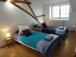a room with two beds and a window at Les chambres du Ladoux in Puy-de-Fourches