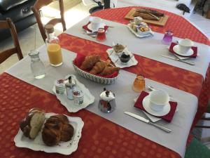 - Mesa con desayuno de bollería y zumo de naranja en Le Clos du Vieux Port, en Véretz