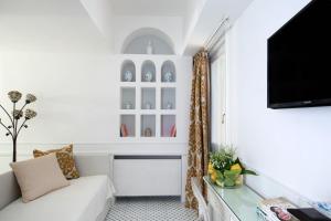 a living room with a couch and a tv at Luxury Villa Excelsior Parco in Capri