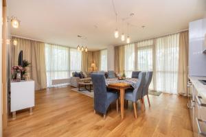 a dining room and living room with a table and chairs at Simpsono apartamentai №215 in Palanga