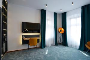 錫比烏的住宿－Kleines Hotel，客房设有书桌和带电视的桌子。