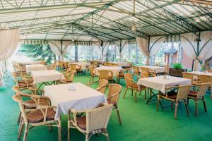 a dining room with tables and chairs in a building at Zolota Gora Hotel-Rancho in Uzhhorod