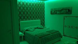 那不勒斯luxury room al cristo velato的绿色卧室配有床和镜子