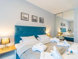a bedroom with a large bed with towels on it at 3L Apartments Aquarius in Kołobrzeg +62 photos