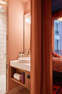 La salle de bains est pourvue d'un lavabo et d'un miroir. dans l'établissement 25hours Hotel Terminus Nord, à Paris