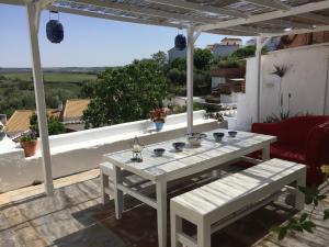 a white table and bench on a patio at La Casa de la Luz. ArtistHome in Almodóvar del Río