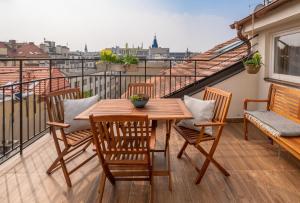 y balcón con mesa y sillas de madera. en City Nest Apartments by Adrez, en Praga
