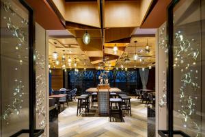 a restaurant with tables and chairs and chandeliers at Just Palace Hotel in Taipei