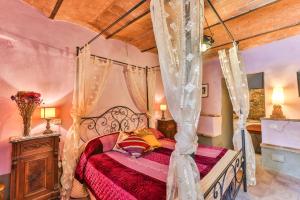 a bedroom with a canopy bed and a wooden ceiling at La Miccia in Pergine Valdarno