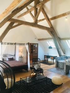 a bedroom with a bed in a room with wooden ceilings at Hameau de la Fausse Sauge in Mézilles