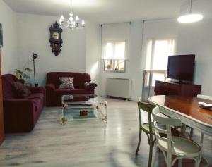 sala de estar con sofá, mesa y reloj en VuT San Blas, en Ciudad Rodrigo