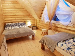 a bedroom with two beds in a log cabin at BeHappy Woodhouse in Jastrzębia Góra