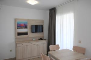 a living room with a dining room table and a television at Apartamentos Playamar in Benidorm