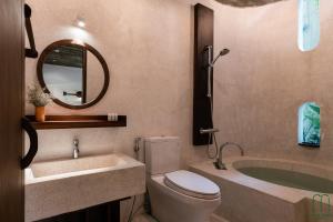 a bathroom with a toilet and a sink and a tub at The Memory - Danang in Da Nang