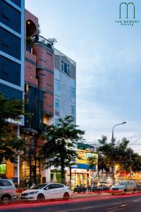 una calle de la ciudad con coches aparcados frente a un edificio en The Memory - Danang, en Da Nang