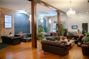 a living room with leather couches and people sitting at Nomads Sydney in Sydney