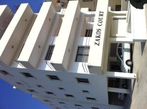 a tall white building with the words on it at Zakos Court Apartments in Larnaca
