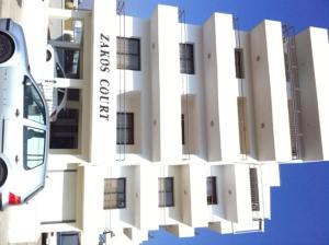 a white building with windows on the side of it at Zakos Court Apartments in Larnaca