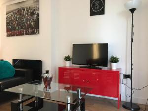 a living room with a red dresser with a television on it at Snapos Apartments - Blonk Street in Sheffield
