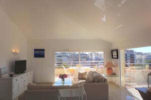 uma sala de estar com um sofá e uma televisão em Spacious and bright flat Downtown and Beaches - Swimming Pool em Antibes