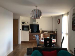 sala de estar y cocina con mesa y sillas en Snapos Apartments - Blonk Street en Sheffield