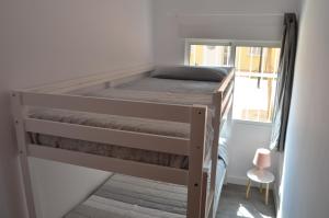 a bunk bed in a small room with a window at Apartament Piramide Complex Alicante Beach in Alicante