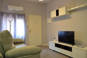 a living room with a couch and a television at Apartament Piramide Complex Alicante Beach in Alicante