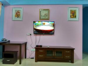un soggiorno con TV su una parete rosa di Tenang & Tranquil Homestay - B605 Cameron Highlands a Brinchang