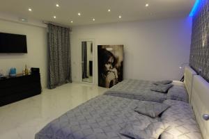 1 dormitorio con 1 cama extragrande y TV en White Room idromassaggio su richiesta, en Nápoles