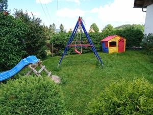 einen Spielplatz mit Rutsche und Spielhaus in der Unterkunft Brosihof in Erlenbach