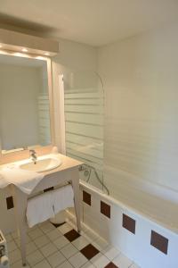 Montagnieu的住宿－Hotel Restaurant Rolland，浴室配有水槽、淋浴和浴缸。