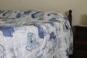 a bed with a blue and white blanket on it at Casa Annuccia in Agerola