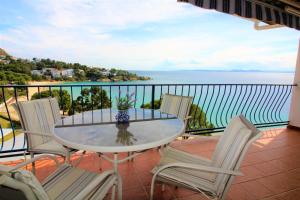 stół i krzesła na balkonie z widokiem na ocean w obiekcie Global Immo 3213 Horizonte Azul w mieście Roses