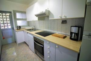 a kitchen with white cabinets and a counter top at Global Immo 3213 Horizonte Azul in Roses