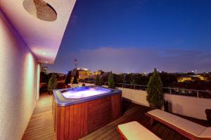 a hot tub on the balcony of a building at Sarroglia Hotel in Bucharest