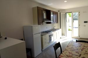 a kitchen with a white refrigerator and a table with chairs at Villa Sofia in Porto Cesareo