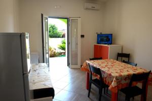 a room with a table and chairs and a television at Villa Sofia in Porto Cesareo