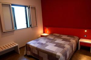 a red bedroom with a bed and a window at Villa Sofia in Porto Cesareo
