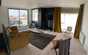 a living room with a couch and a table at VILLA "Le LOFT" in Wimereux