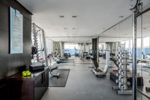 een fitnessruimte met rijen loopbanden en machines bij The Canvas Dubai - MGallery Hotel Collection in Dubai