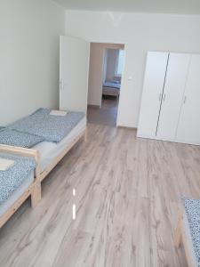 Habitación con 2 camas y suelo de madera. en Apartmány Karviná en Karviná