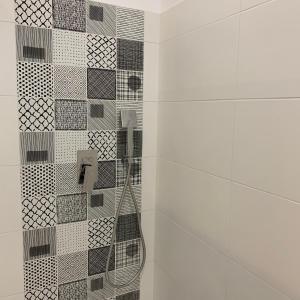 a bathroom with a shower with a tiled wall at VILLA "Le LOFT" in Wimereux