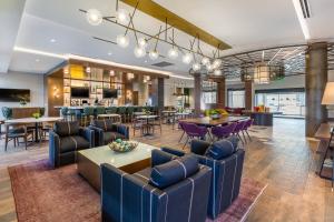 a lobby with couches and tables and a bar at Cambria Hotel - Arundel Mills BWI Airport in Hanover